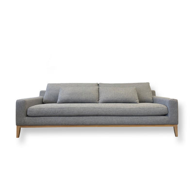 Luxury deep seat cream fabric sofa.  Scandinavian inspired minimalist designed modern couch.  Exposed natural oak wood base and a single cushion configuration.