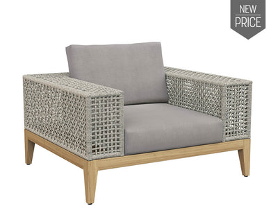 bold armchair from the Outdoor by SUNPAN collection. Features a deep seat in palazzo taupe fabric with wide powder coated aluminum armrests wrapped in a greymix weave. A solid natural teak wood frame completes the design.